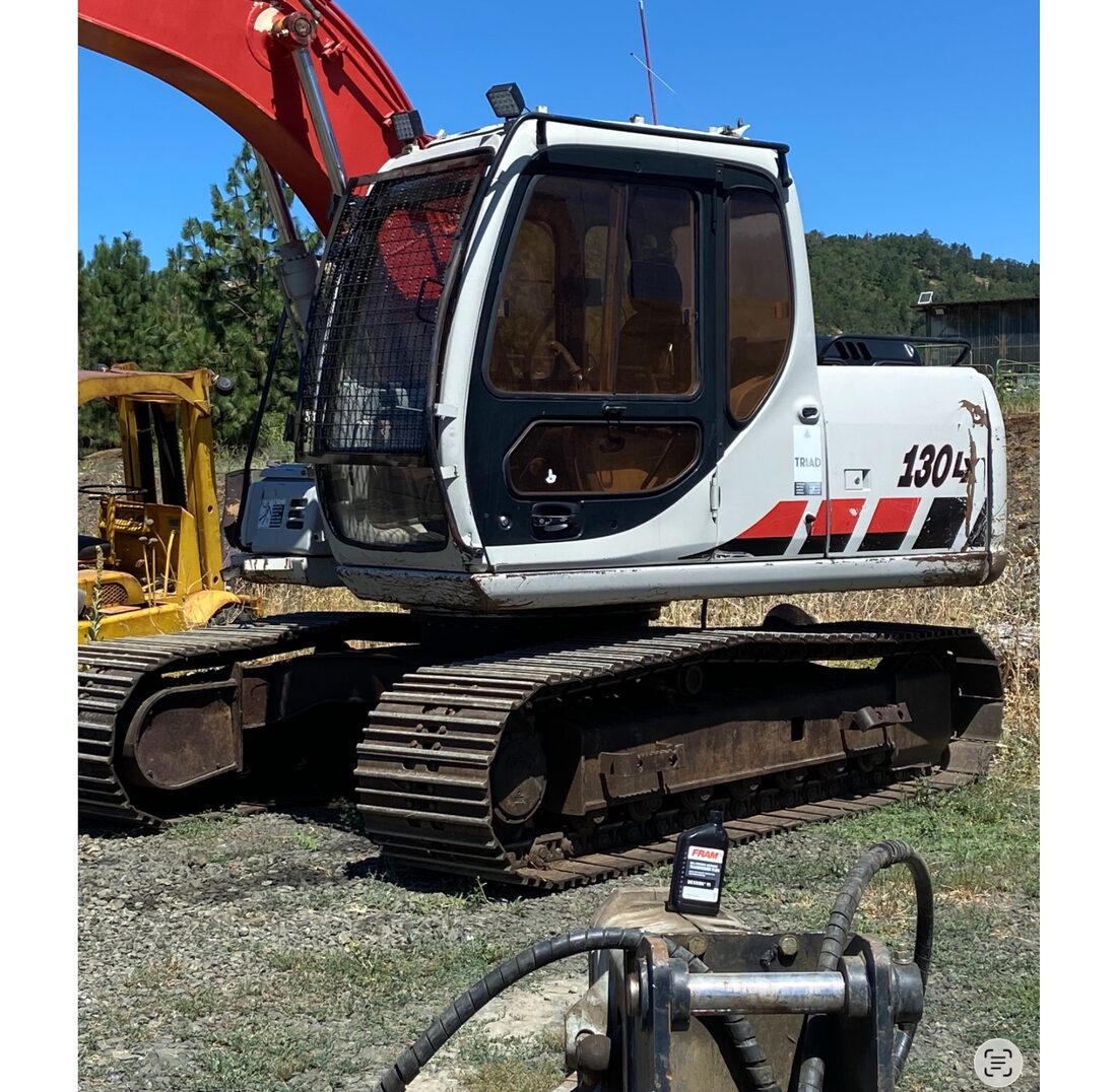 Russco's full-size excavator with hydraulic breaker, the equipment used for dump truck hauling & material delivery jobs.